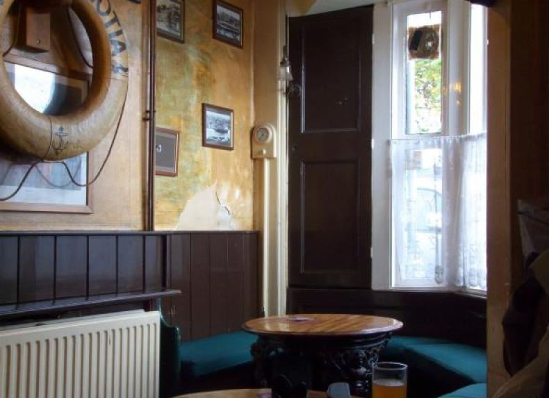 Wood-pannelled interior of pub with nautical decorations on walls